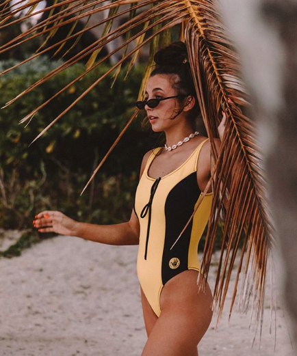 Emma Chamberlain posing for a photoshoot on a trip to Fiji sponsored by the clothing company Dote