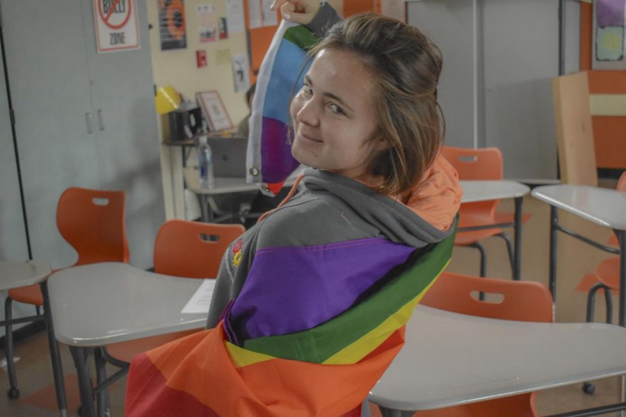 Rachelle Taveau, a Woodside junior, holding a LGBTQ pride flag.
