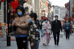 People wearing protective face masks walk on a street in Beijing, Sunday, Feb. 23, 2020. South Korea and China both reported a rise in new virus cases on Sunday, as the South Korean prime minister warned that the fast-spreading outbreak linked to a local church and a hospital in the countrys southeast had entered a more grave stage. (AP Photo/Andy Wong)