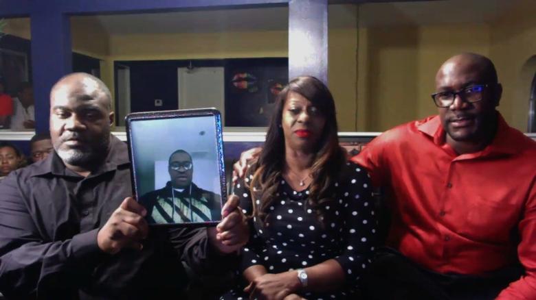 During an interview with CNN, George Floyds two brothers and cousin hold up a photo of Floyd.