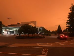 An orange, hazy cover of smoke is seen above the Woodside traffic circle and PAC on September 9th, 2020. The large amounts of smoke from the fire have been causing a variety of inconveniences for Woodside students and teachers since the fires were started less than a month earlier