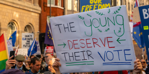 A student holds up a sign saying