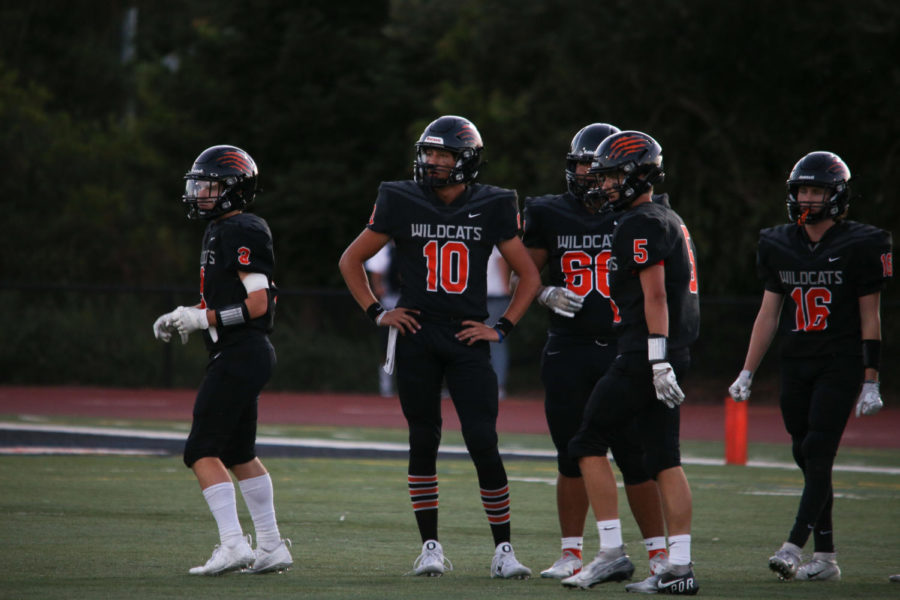 Woodside Quarterback Ben Shepard (number 10) meets with team members during Woodside’s game last month against Aragon. Woodside lost its recent game against Cupertino and now has a 3-1 record.