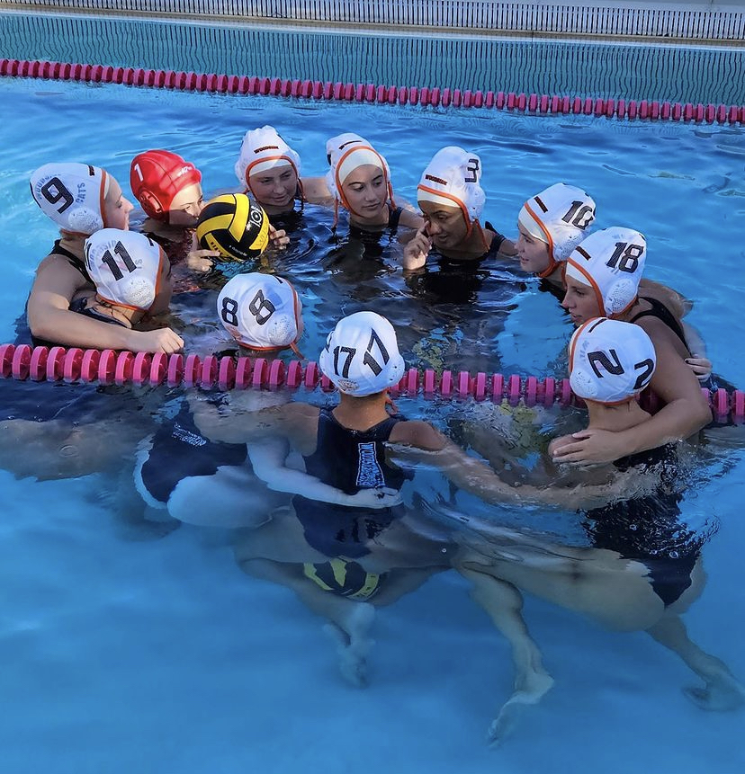 Girls Varsity Waterpolo huddled up after defeating Aragon 11-2.