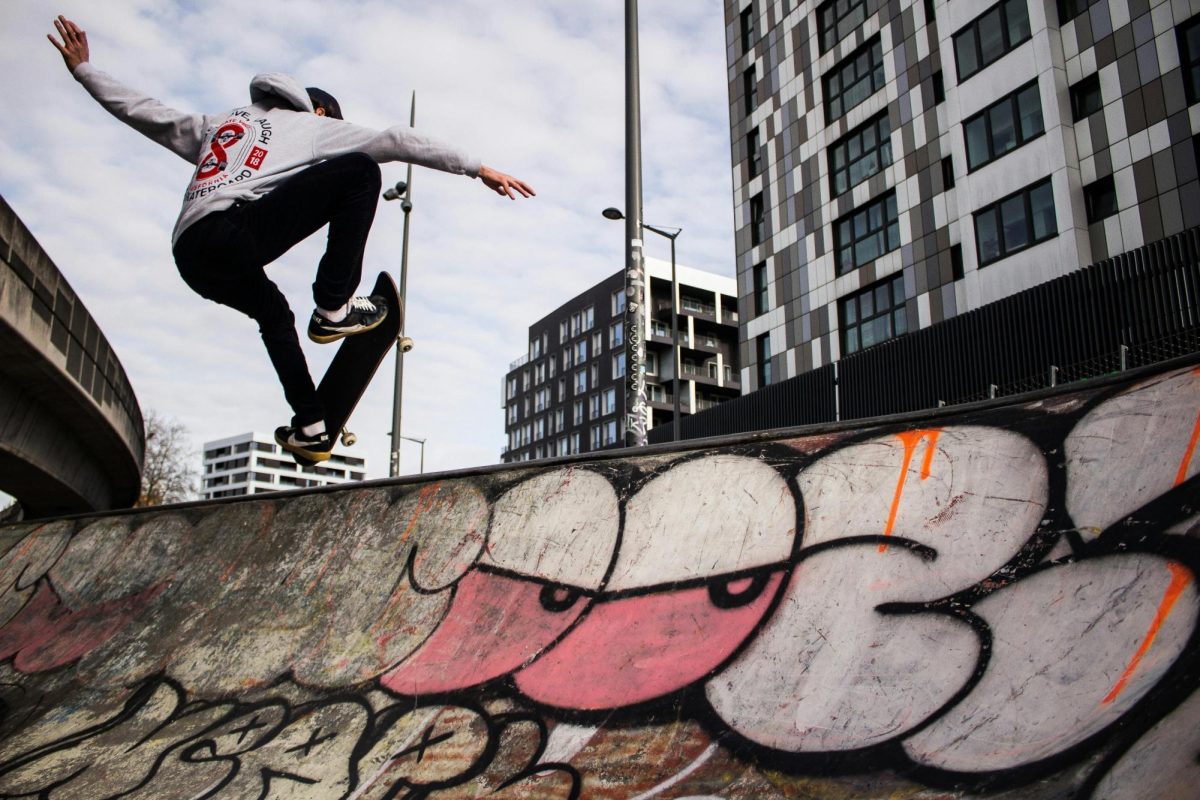 Image of a man skateboarding in a graffitied skate park.