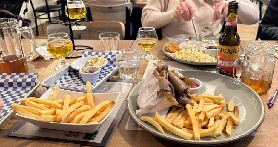 Lamb in a pita wrap with a side of fries and a German orange coca cola.