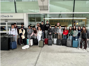 Students are in front of the airport doors preparing to depart for the tour.