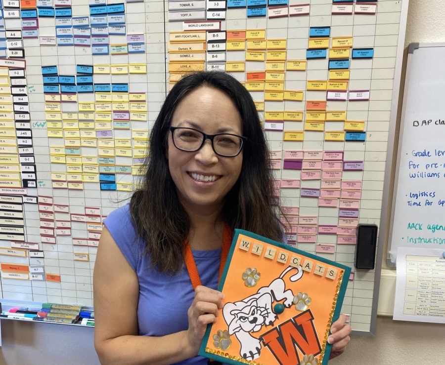 Ms. Philippe holding up her decorated La Entrada graduation cap.