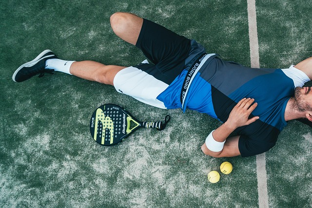 An exhausted athlete lying on the ground after playing tennis.