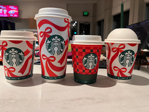 Starbucks winter drinks in festive cups lined up next to each other.