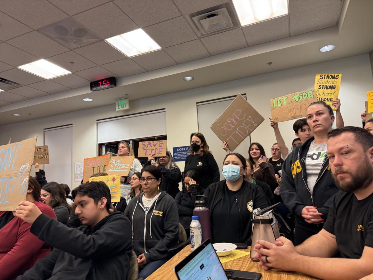 Members of the community filled the audience of the SUHSD board meeting with signs protesting the decision to close TIDE.
