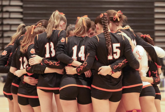 The Woodside varsity volleyball team in  a huddle during their game against Half Moon Bay.
