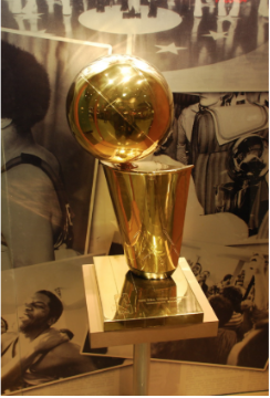 The Larry O’Brien Championship trophy with a background of old iconic NBA moments